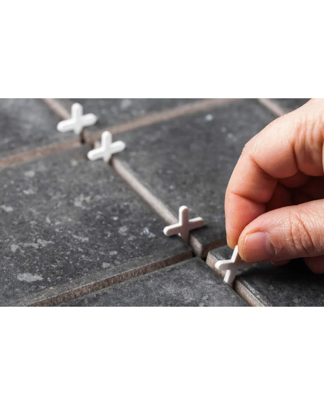Installing tile spacers during floor tiling for accurate spacing and alignment